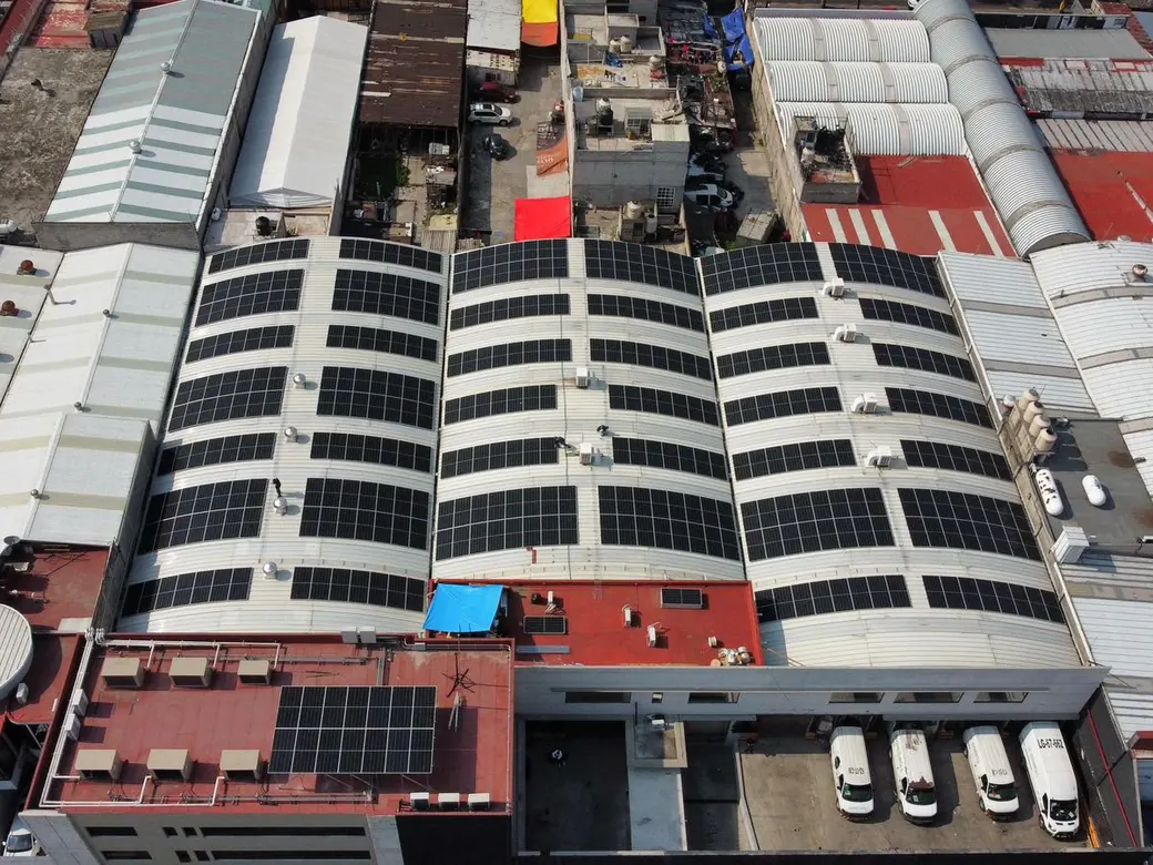 Las naves con módulos solares vistas desde lo alto, entre los techos de la zona industrial
