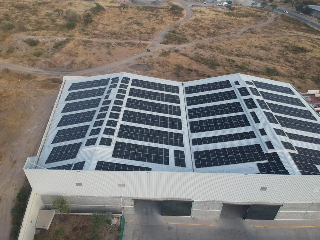 Nave de Rollos de Plásticos en Otates con la techumbre de dos aguas cubierta de módulos, vista desde el dron